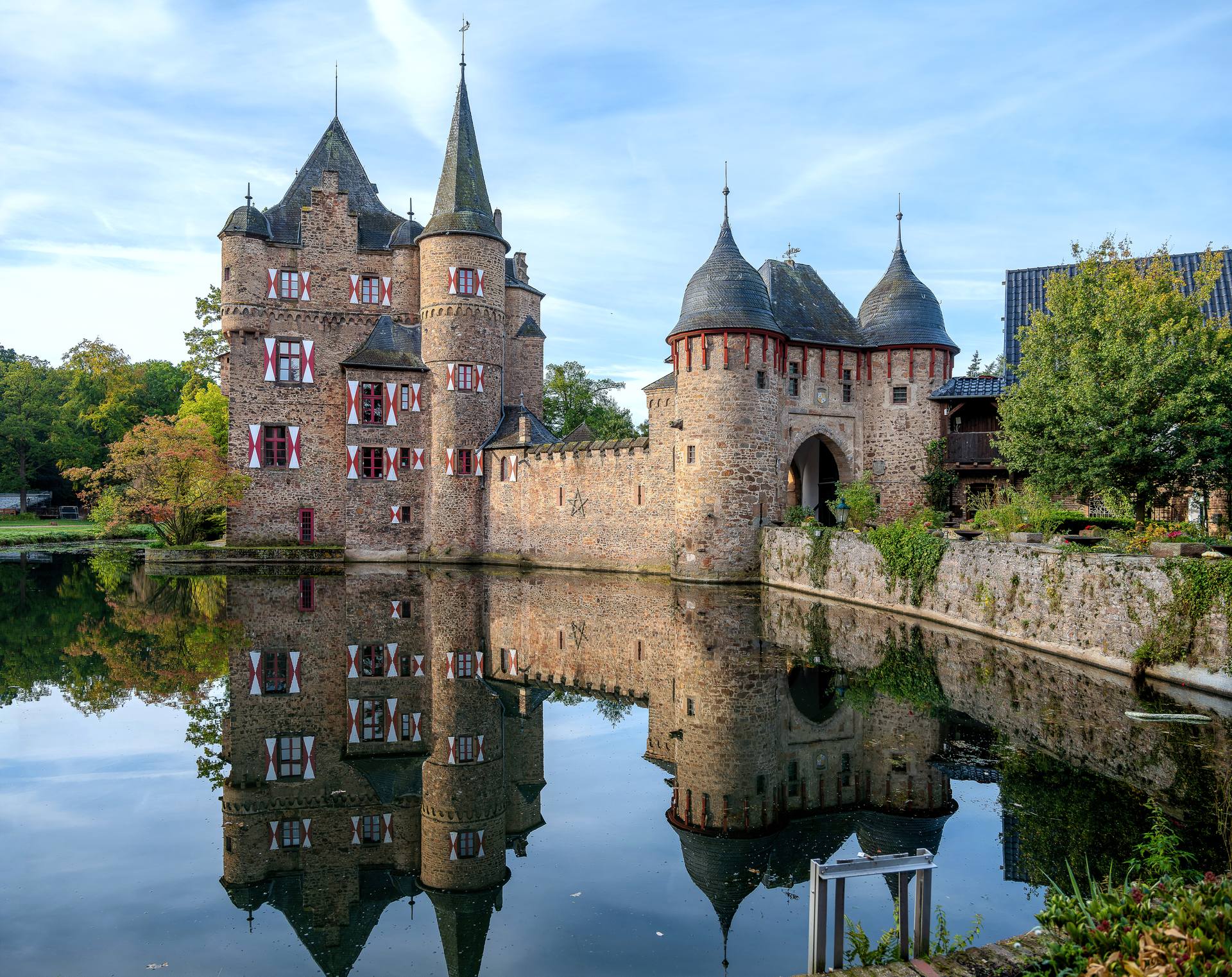 Wasserburg Satzvey in Mechernich, die mittelalterliche Burg mit Torhaus und Türmen, gespiegelt im Wasser des Burggrabens