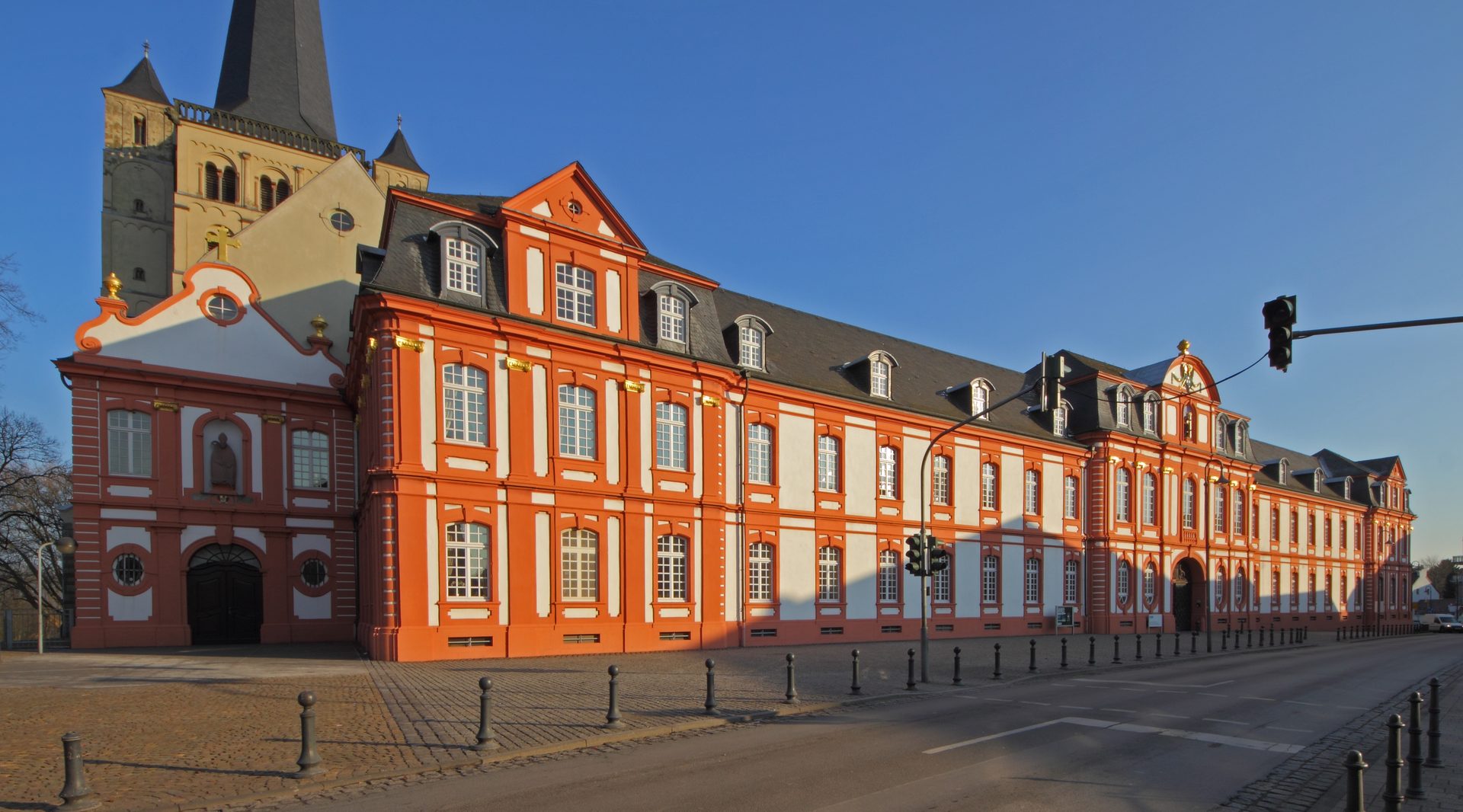 Abtei Brauweiler in Pulheim, barocke Klostergebäude mit den romanischen Türmen der Abteikirche St. Nikolaus unter blauem Himmel
