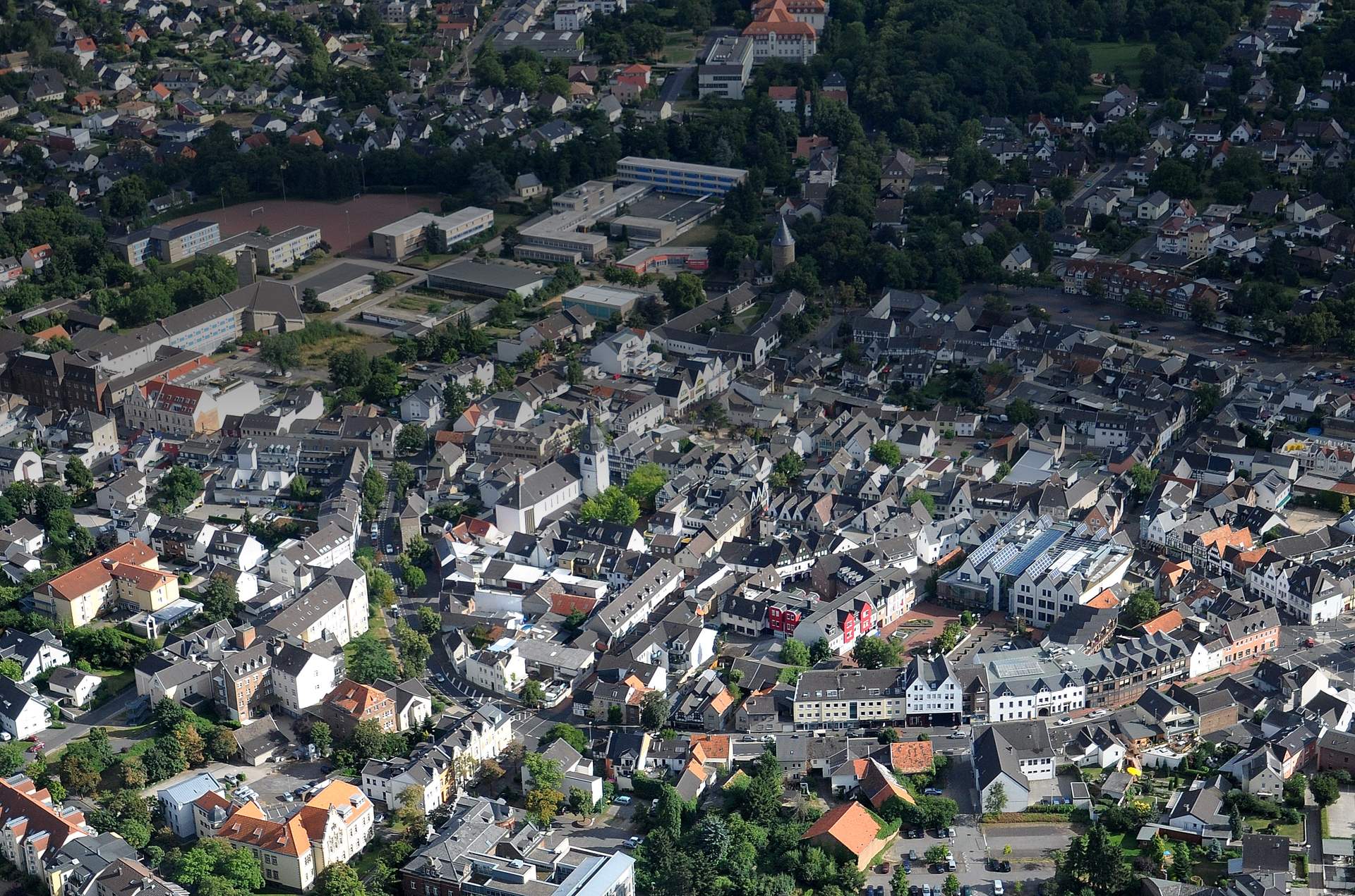 Luftaufnahme der Rheinbacher Innenstadt, die dichte Dachlandschaft der Altstadt mit ihren Kirchtürmen vor der offenen Landschaft der Voreifel