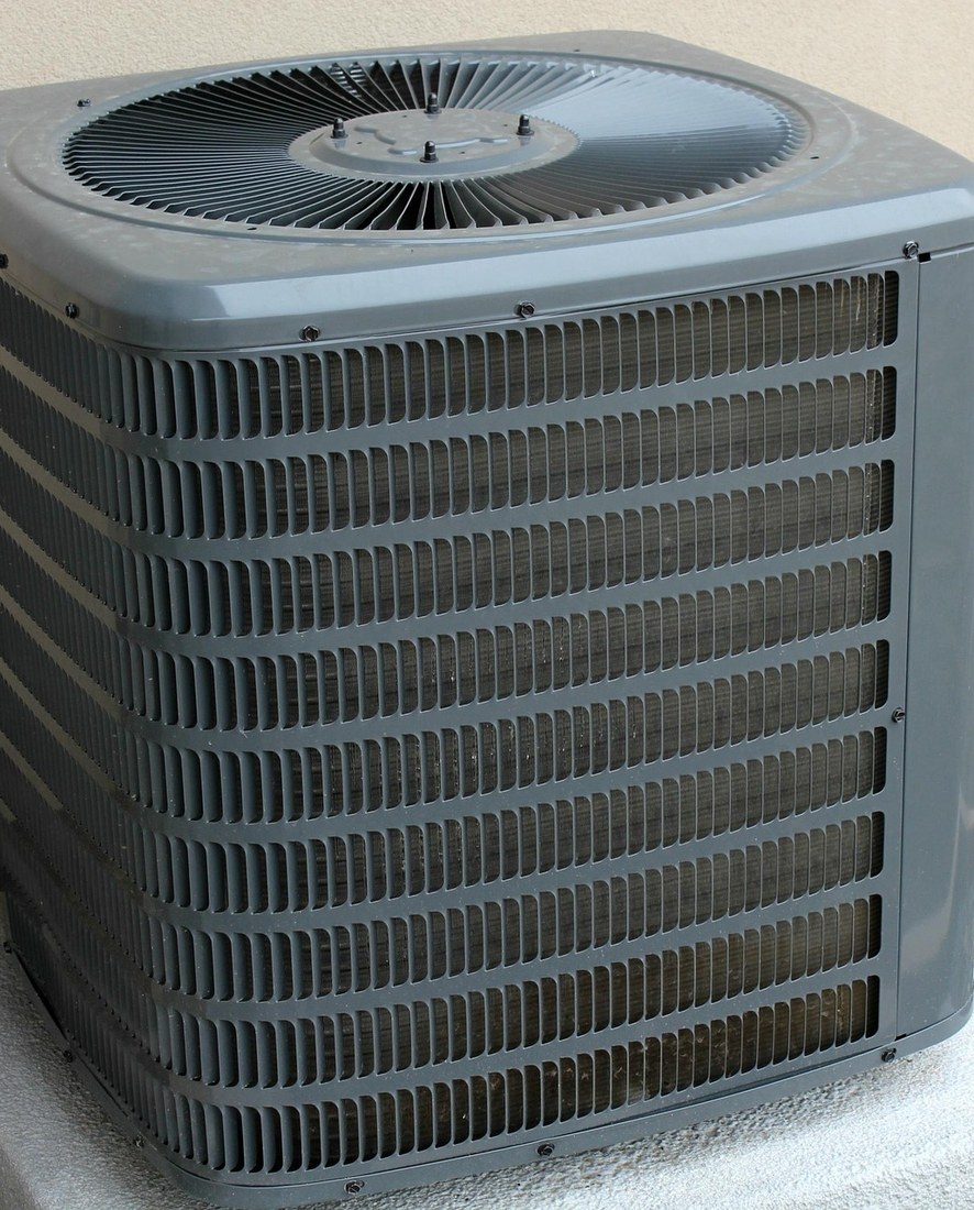 Wärmepumpe neben einem Haus mit Solardach
